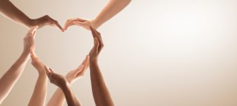 multiple hands of varied skin tone shaped to form a heart