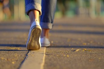 Close up of a person's shoes as they are walking on a street