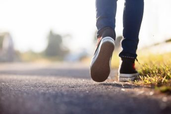 close up of a person's lower legs and shoes as they are walking along a path